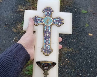 Peut inclure: Croix murale en albâtre blanc avec un incrustation d'émail bleu, or et blanc. La croix a un petit calice orné de couleur or attaché au bas.