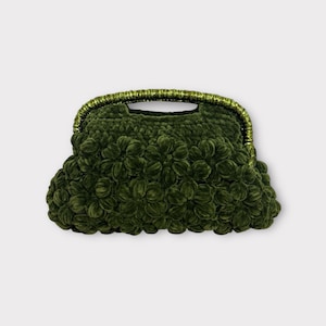 May include: A dark green, textured handbag with a rounded shape. The bag features a handle with gold trim and is covered in a floral-like pattern. The bag is made of a soft, plush material.