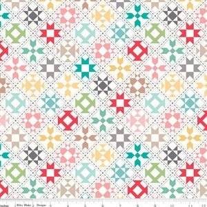 May include: A colorful patchwork fabric with a repeating pattern of geometric shapes. The design features squares with various star and diamond patterns in shades of red, green, blue, pink, and yellow, set against a white background. The fabric is measured in inches.