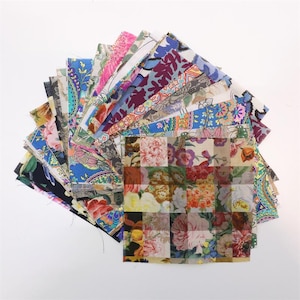 Puede incluir: Una colección de cuadrados de tela con diversos estampados florales y de cachemira. Las telas presentan una mezcla de colores, incluyendo azul, rosa, morado y naranja. Los cuadrados están dispuestos en forma de abanico, mostrando la variedad de diseños.