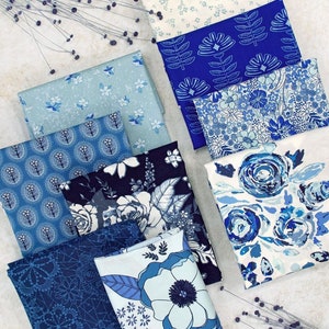 Puede incluir: Una colección de ocho cuadrados de tela azul y blanca con varios patrones florales y geométricos. Las telas están dispuestas en un patrón escalonado sobre una superficie gris claro.