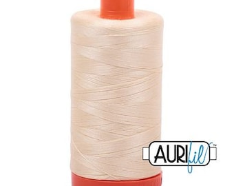 Puede incluir: Una bobina de hilo beige con tapa y base naranja. El hilo está bien enrollado y la bobina tiene el logotipo de Aurifil en el lateral. Ideal para proyectos de costura y acolchado.