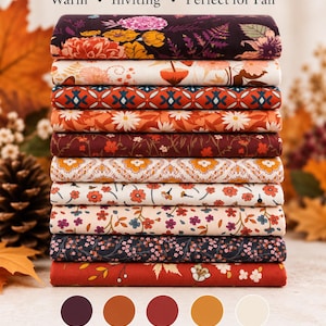 Pode incluir: Uma pilha de 10 fat quarters de tecido 100% algodão para quilting com vários padrões florais e geométricos em tons de canela, baga, laranja, creme e castanho escuro, rotulados Cinnamon & Berry com amostras de cores.