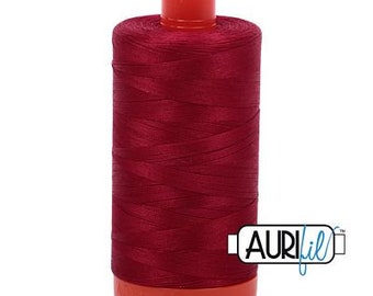 May include: A spool of deep red thread with a red plastic bobbin and the word "Aurifil" printed on the side.
