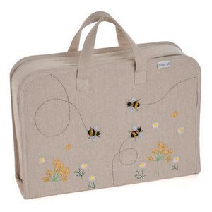 Puede incluir: Una bolsa de lona beige con abejas y flores bordadas. La bolsa tiene dos asas y una cremallera. El texto "Hobby Gift" está bordado en la bolsa.