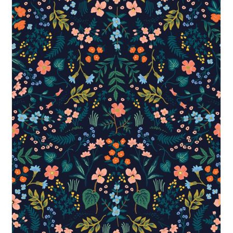 Op de afbeelding: Een donkerblauwe stof met een herhalend patroon van roze, oranje en blauwe bloemen. De bloemen worden omringd door groene bladeren en stengels.