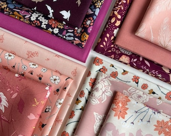 May include: A stack of fabric featuring floral patterns in shades of pink, burgundy, and cream. The fabric is arranged in a fan shape, with the top layer showing a pattern of white birds on a burgundy background.