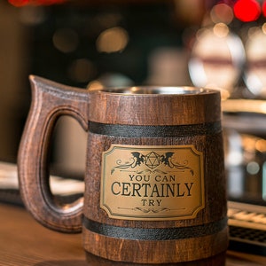 May include: A brown wooden beer stein with a black band around the top and bottom. The stein has a metal plate with the text "You can certainly try" and a stylized image of a 20-sided die.