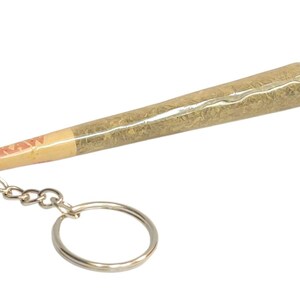 May include: A silver keychain with a realistic-looking joint, wrapped in a brown paper with the word "RAW" printed on it.