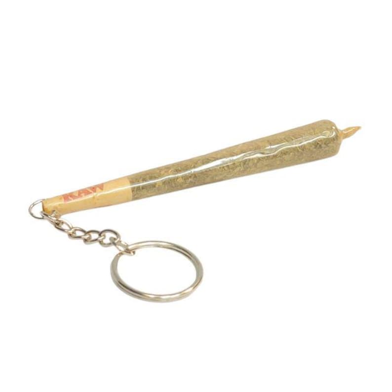 May include: A silver keychain with a realistic-looking, rolled-up joint. The joint is labeled "RAW" and is about 4 inches long.