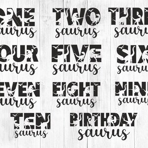 May include: Black and white dinosaur-themed digital designs. The image features the words "ONE" through "TEN" and "BIRTHDAY" with the word "saurus" below each number. Each word has a dinosaur silhouette inside.