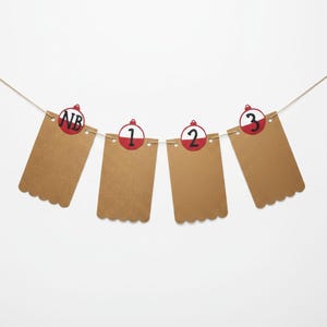 May include: A brown paper banner with scalloped edges, strung on twine. Each banner has a red and white circular design with numbers 1, 2, and 3, and the letters "NB". The background is white.