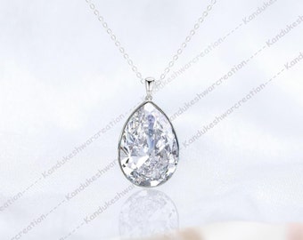May include: A silver chain necklace with a pear-shaped clear crystal pendant.