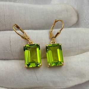 Puede incluir: Un par de pendientes de oro con gotas rectangulares de piedra preciosa verde. Los pendientes tienen un cierre de palanca.