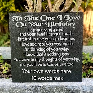 May include: A square black slate memorial plaque featuring engraved white text that reads: To The One I Love On Your Birthday, followed by a poem about missing a loved one, and two lines at the bottom for custom text with a 10 words max limit.