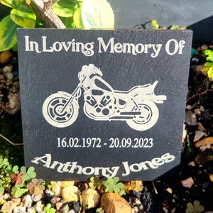 May include: Black slate memorial plaque with a silver motorcycle silhouette, the text "In Loving Memory Of", the dates "16.02.1972 - 20.09.2023", and the name "Anthony Jones".