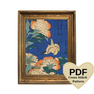 May include: A cross stitch pattern featuring a Japanese woodblock print of a bird flying over a field of white and orange peonies. The pattern is in a gold frame and includes the text "PDF Cross Stitch Pattern".