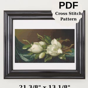 以下が含まれることがあります： 白いモクレンの花と緑の葉とつぼみを描いた、額入りのクロスステッチパターン。 作品は、ティール色の生地を背景に、暗い背景に設定されています。 フレームのサイズは54.3 cm x 33.3 cmです。 「PDF Cross Stitch Pattern」の文字が見えます。