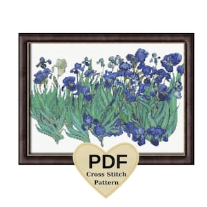 May include: Cross-stitch pattern of blue irises in a field, framed in a dark brown border. The flowers have detailed blue petals and green leaves. A heart-shaped graphic at the bottom reads "PDF Cross Stitch Pattern."