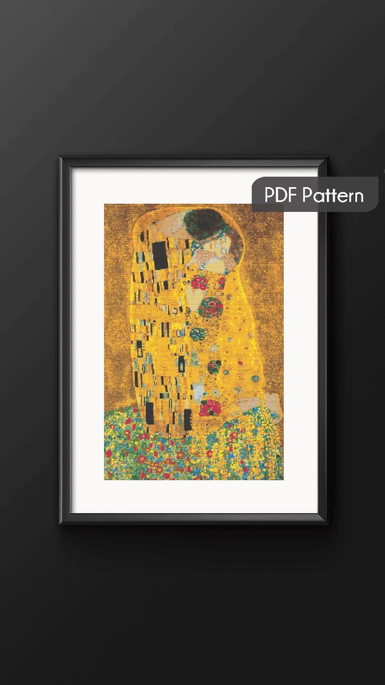 Op de afbeelding: Een kruissteekpatroon van Gustav Klimt's schilderij "De Kus". Het patroon toont twee figuren in een gouden omhelzing, omringd door een veld met kleurrijke bloemen.