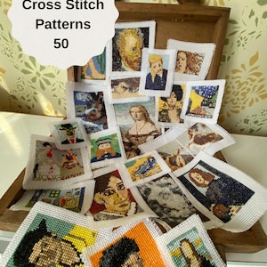 May include: A wooden box filled with 50 small cross stitch patterns, each featuring a different famous painting. The box has a handle and is open, revealing the patterns inside. The patterns are all white with colourful embroidery.