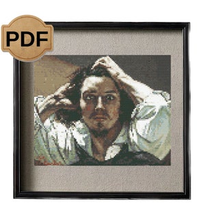 May include: A framed cross-stitch artwork depicting a man with dark hair and a white shirt, looking thoughtfully at the viewer. The man's hand is on his head, and his expression is serious. The artwork is framed in a black frame with a gray mat.