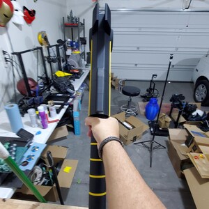 Puede incluir: Un arma de utiler&iacute;a negra y amarilla con una superficie texturizada. El arma est&aacute; siendo sostenida por la mano de una persona.