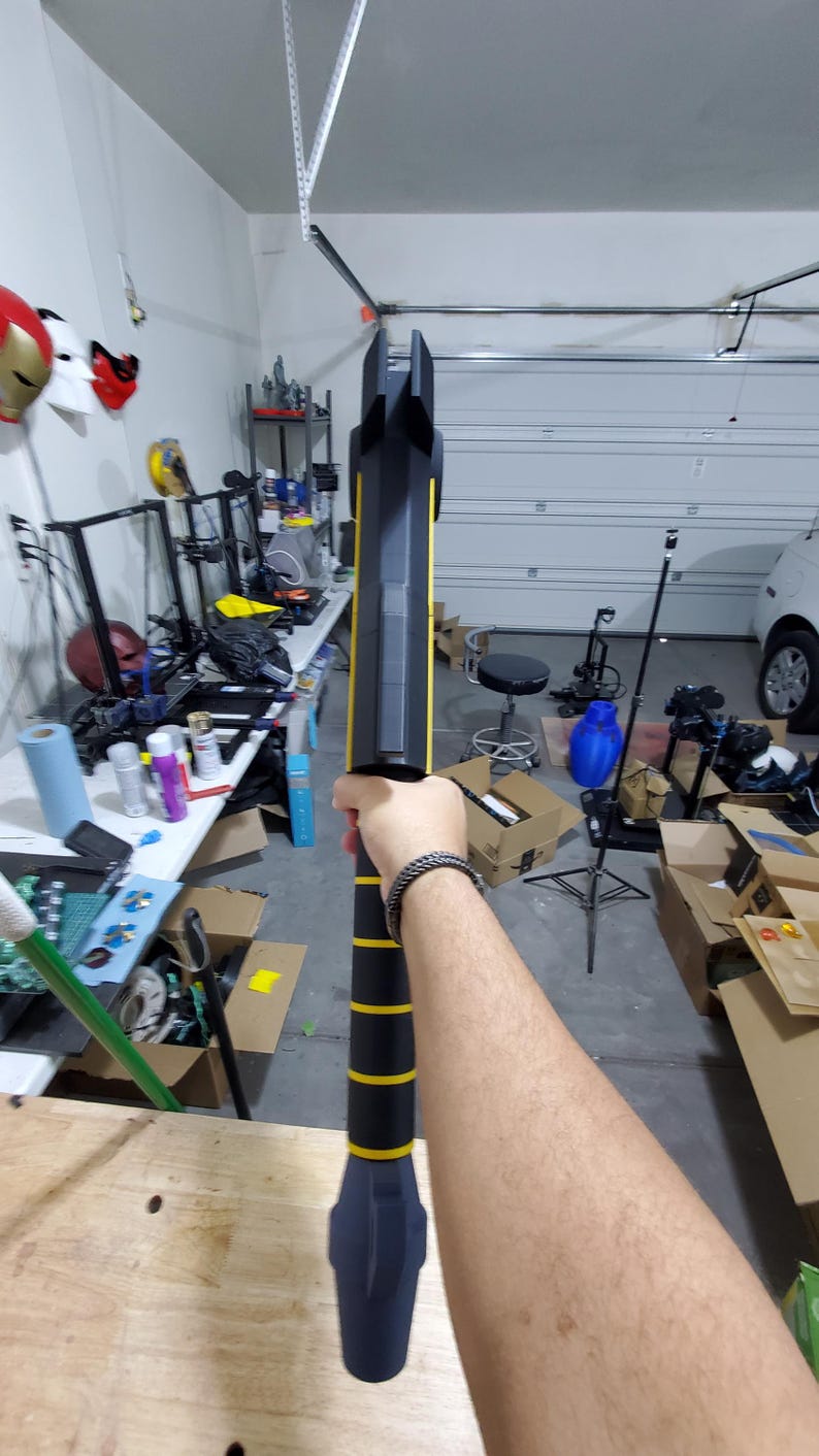 Puede incluir: Un arma de utiler&iacute;a negra y amarilla con una superficie texturizada. El arma est&aacute; siendo sostenida por la mano de una persona.