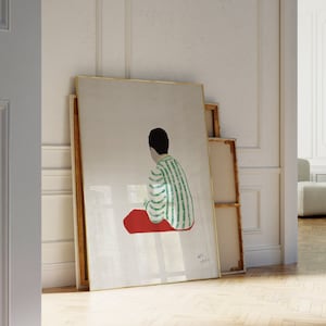 May include: A framed illustration of a person sitting with their back to the viewer, wearing a green and white striped shirt and red pants. The illustration is on a white background.
