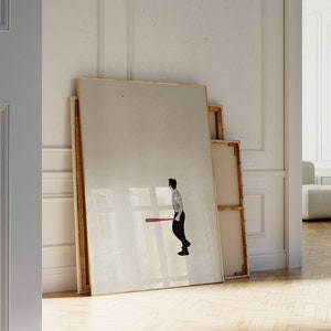 May include: A white room with a large framed mirror leaning against a wall. The mirror reflects a person holding a red baseball bat. The room has white walls and a wooden floor.