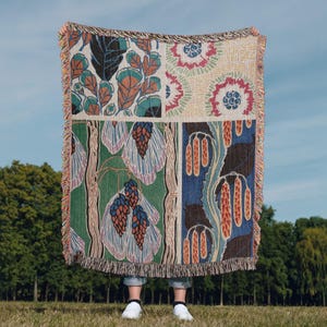 May include: A woven tapestry throw blanket featuring a colourful floral pattern. The blanket is made up of four different panels, each with a unique design. The panels are sewn together to create a cohesive look. The blanket is fringed on all sides.