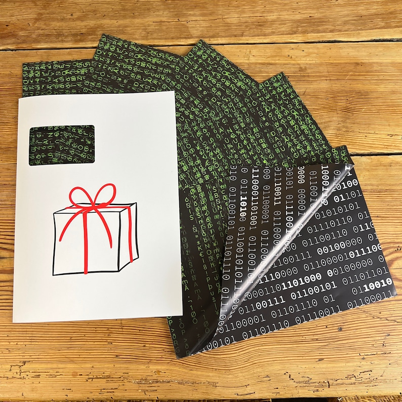 以下が含まれることがあります： 赤いリボンと弓が付いた白いギフトボックス。ボックスは、バイナリコードの黒と緑のパターンが施された白い背景の上にあります。