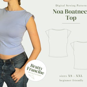 Könnte beinhalten: Ein hellblaues Bootneck-Top mit Flügelärmeln wird auf einem Model gezeigt, kombiniert mit Jeans. Das Bild enthält auch ein digitales Schnittmuster für das "Noa Boatneck Top" in den Größen XS bis XXL, das als anfängerfreundlich beschrieben wird.