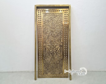 May include: A decorative brass door panel with intricate geometric patterns and a border of round studs. The panel is framed with a thin brass border.