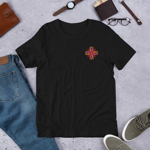 Peut inclure: T-shirt noir avec un motif floral brodé coloré sur la poitrine. Le motif présente un motif symétrique dans les tons de rose, d'orange et de jaune. Le t-shirt est fait d'une matière douce et convient aux tenues décontractées.