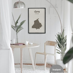 K&ouml;nnte beinhalten: Eine druckbare Karte von Punjab, Indien, mit dem Namen des Bundesstaates in Englisch und Punjabi. Die Karte ist auf beigefarbenem Hintergrund gedruckt und schwarz gerahmt. Die Karte wird an einer wei&szlig;en Wand in einem Raum mit einem wei&szlig;en Tisch und St&uuml;hlen, einer Topfpflanze und einer Stehlampe angezeigt.