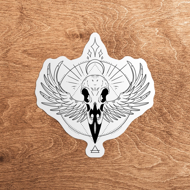 May include: Black and white illustration of a crow skull with wings spread wide. The skull is surrounded by a geometric design with a circle and a triangle.