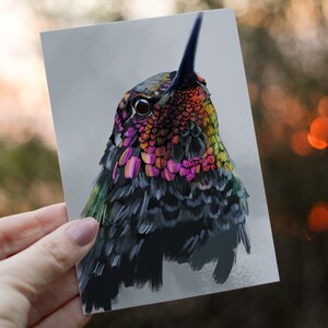 May include: Close-up of a hummingbird with iridescent green, pink, and yellow feathers. The bird's eye is visible, and it is looking up.