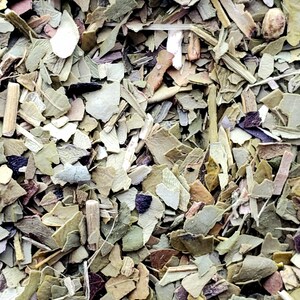 May include: Close-up of dried yerba mate leaves, displaying a mix of green, brown, and tan shades. The leaves are fragmented, with visible stems and varying textures. The image highlights the natural, organic appearance of the tea.