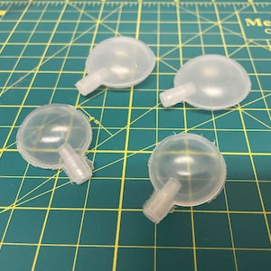 May include: Four clear plastic dog squeaky toys. The toys are shaped like balls with a small, clear plastic tube attached to the bottom.