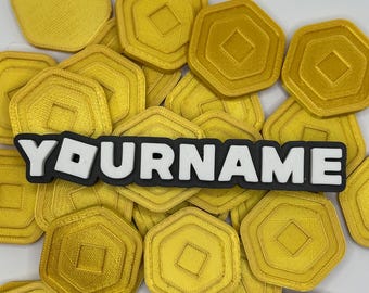 May include: A black and white custom name tag with the text "YOURNAME" on a bed of gold hexagonal coins.