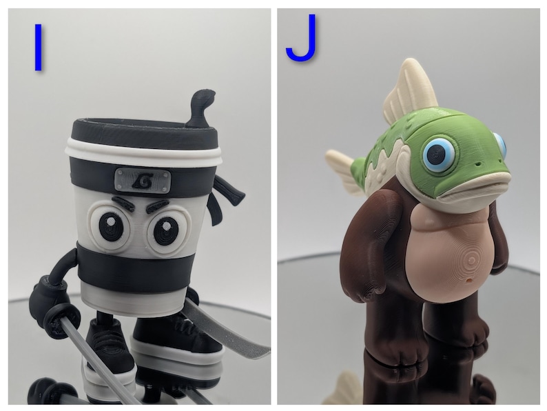 Puede incluir: Dos figuras caprichosas. Una es una taza de caf&eacute; ninja con una diadema negra, sosteniendo espadas y usando zapatillas. La otra es una criatura parecida a un pez con cabeza verde, aletas blancas y cuerpo marr&oacute;n.