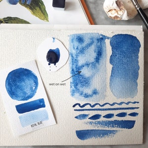 Puede incluir: Una demostración de pintura acuarela que muestra diferentes técnicas para usar pintura azul real. La imagen muestra una técnica húmeda sobre húmeda, una técnica de pincel seco y una técnica de lavado. El texto "wet on wet" está escrito en la imagen.