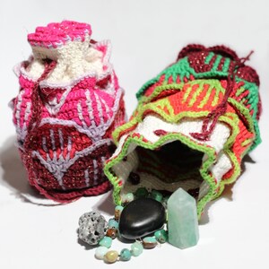 May include: Two crocheted drawstring bags, one pink and one green, with a variety of colourful stones and crystals spilling out of the green bag.