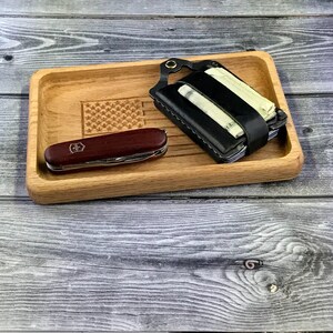 May include: A wooden tray with a laser-engraved American flag design. The tray features a black leather wallet with a money clip and a red and silver pocket knife.