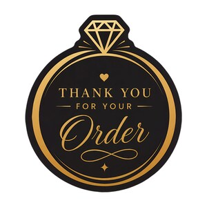 May include: A circular black sticker with a gold border and a diamond ring icon at the top. The text reads THANK YOU FOR YOUR Order in a mix of serif and script fonts, accented by a small heart and decorative flourishes in gold on a black background.