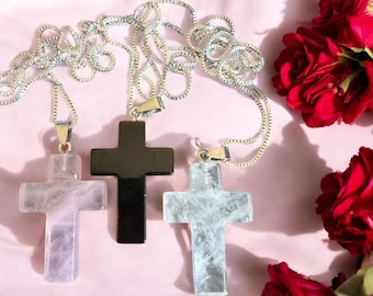 May include: Three silver chains with different crystal cross pendants. The crosses are made of clear quartz, rose quartz, and black onyx.