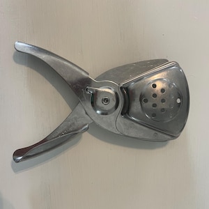 May include: A white ceramic mug with a black handle and the text "But First, Coffee" in a handwritten style. The mug is on a white surface. The mug is 4 inches tall.