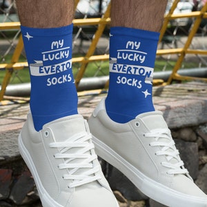 Puede incluir: Un par de calcetines azules con texto blanco que dice "My Lucky Everton Socks". Los calcetines los lleva una persona que lleva zapatillas blancas.