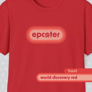 May include: A red t-shirt with the word "epcoter" in a light orange oval. Below the oval is a rectangular label that says "world discovery red" in white text. The word "front" is above the label.